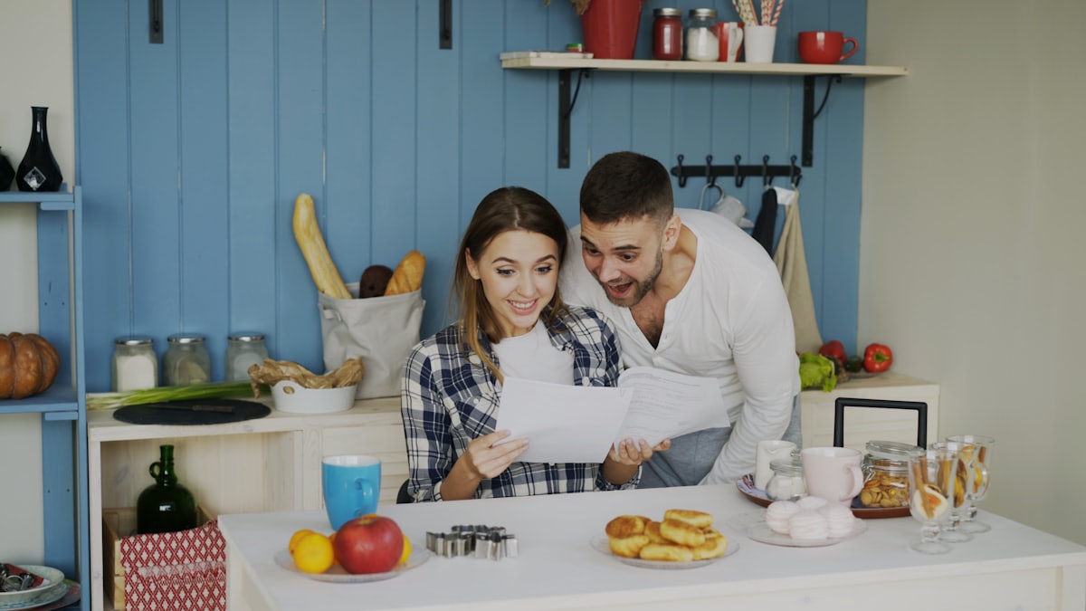 Two clients reviewing their account paperwork together at home.